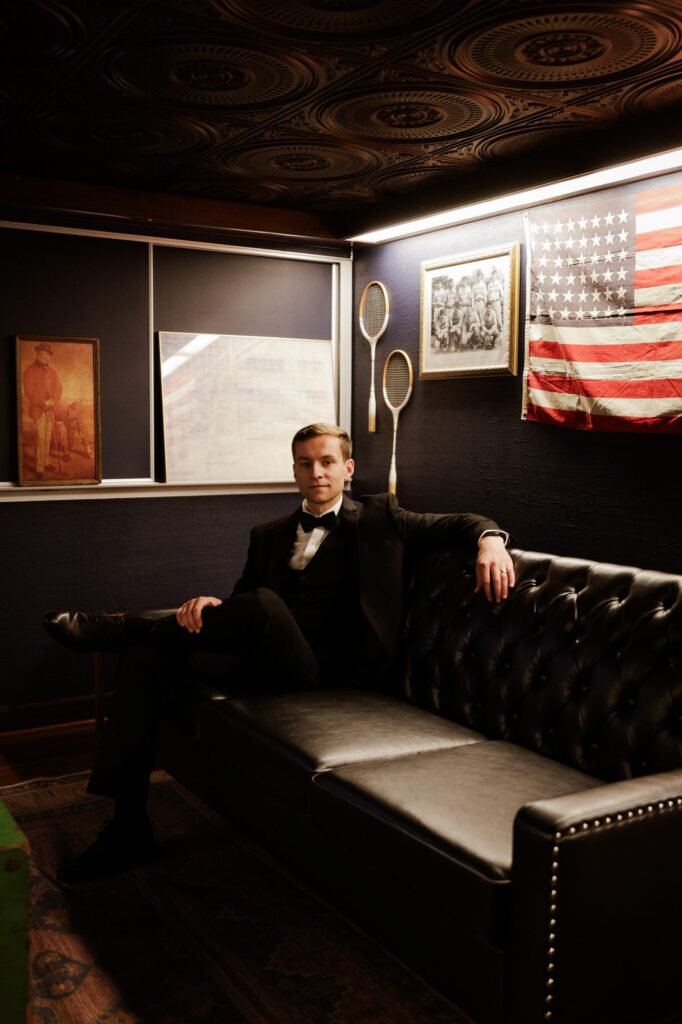 Groom seated in the speakeasy-style grooms lounge at The Event Vault