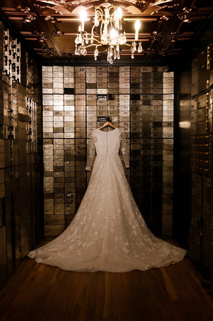 Wedding dress hanging inside the glass-tiled vault at The Event Vault in Urbana