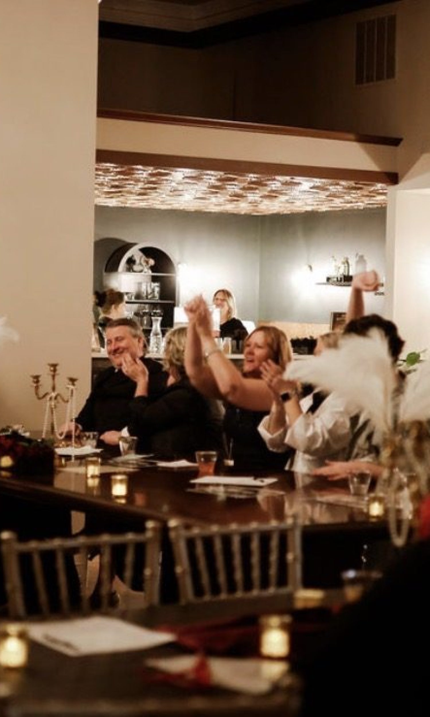 Guests applauding at a candlelit dinner event at The Event Vault