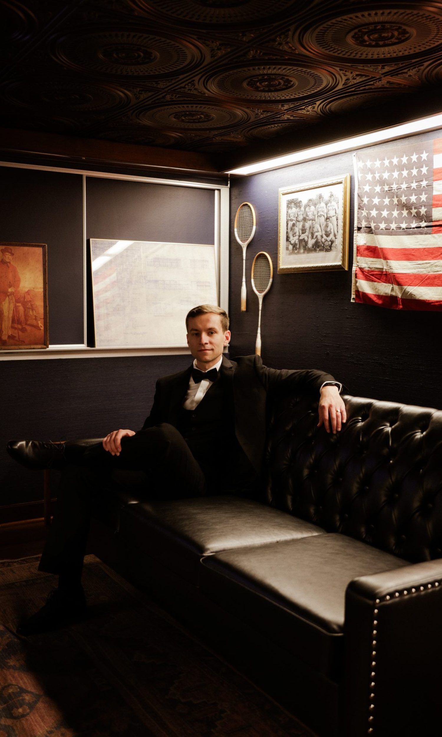 Groom seated in the speakeasy-style grooms lounge at The Event Vault