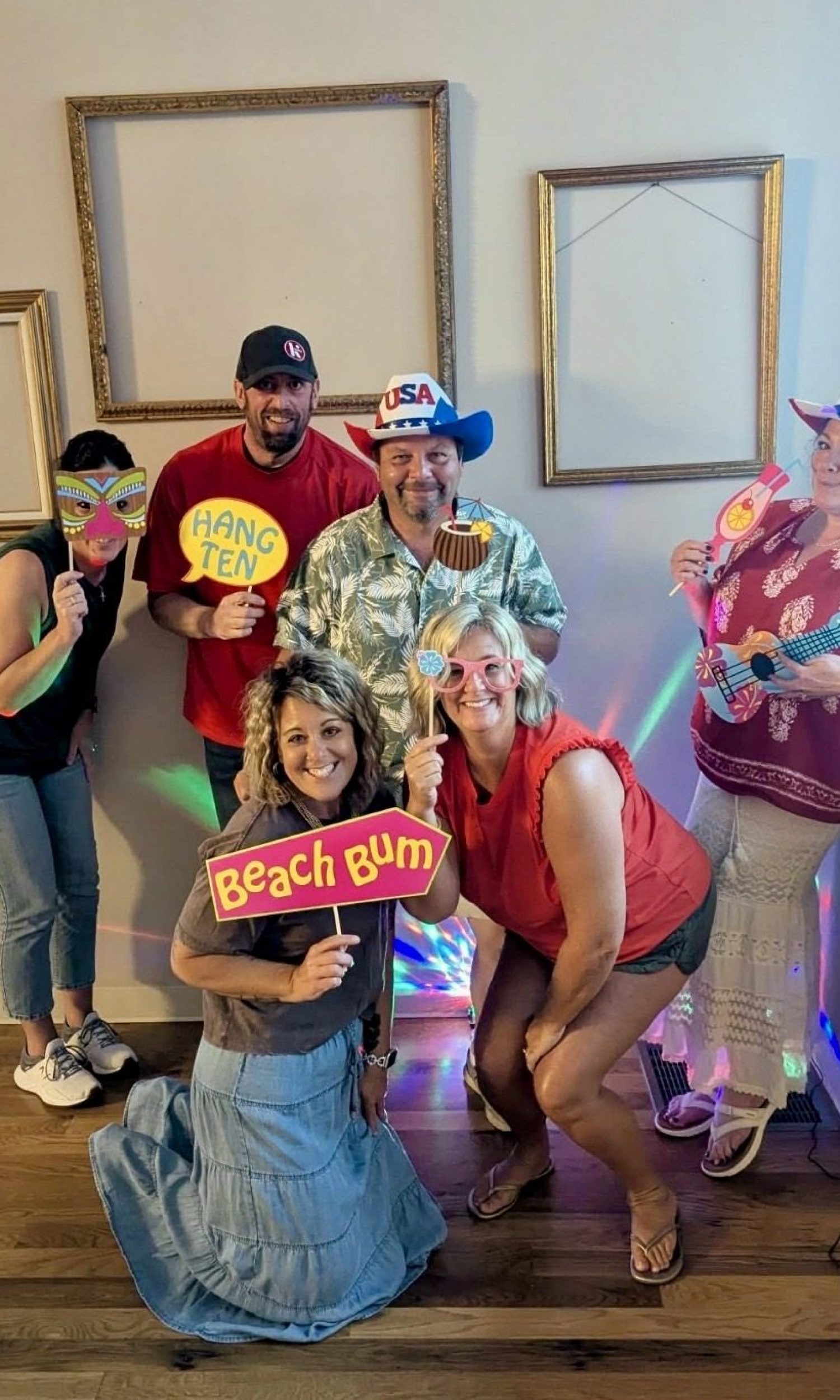 Guests posing with photo props at a summer social at The Event Vault