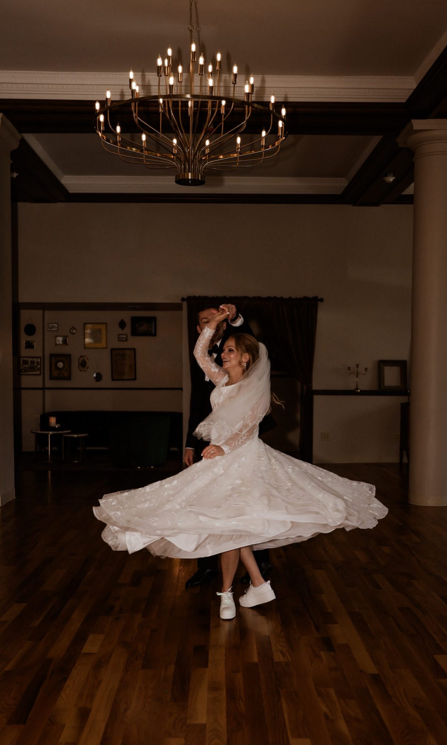 Bride twirling on the dance floor beneath the chandelier at The Event Vault